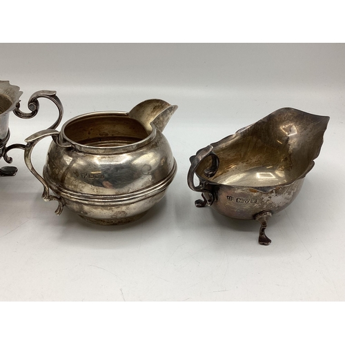 78 - Three sterling silver items, to include footed sugar bowl, cream jug and small sauce boat, various d... 