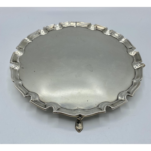 35 - A sterling silver circular card tray with cast border on three feet. 21cm(d) by Edward Barnard & Son... 