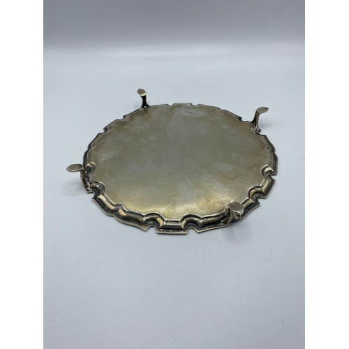 35 - A sterling silver circular card tray with cast border on three feet. 21cm(d) by Edward Barnard & Son... 