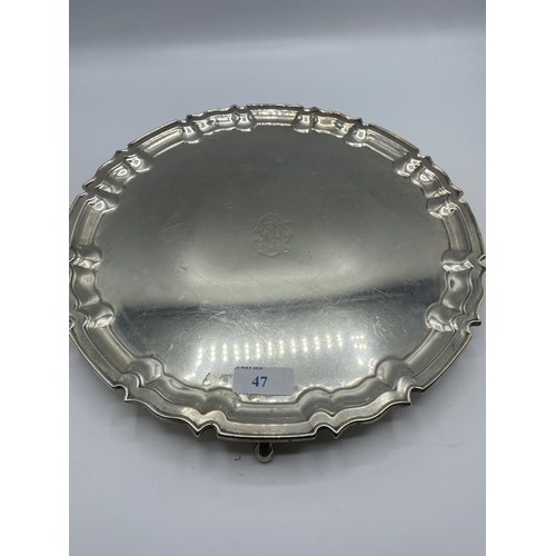 47 - A sterling silver circular tray on three scroll feet by William Hutton and Sons Ltd, Sheffield 1922.... 