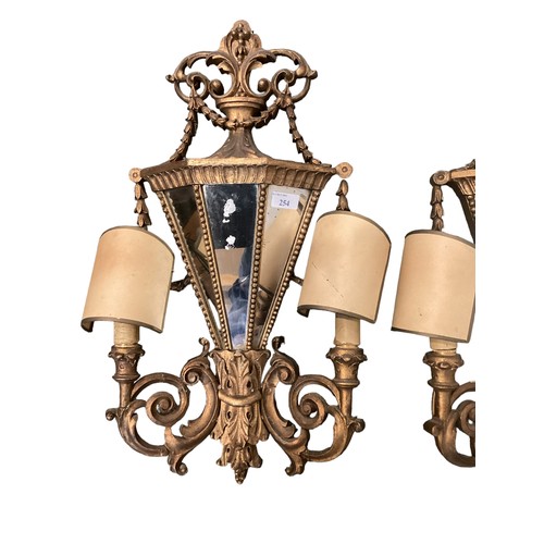 254 - A pair of late C19th wall sconces, with mirrored backs and carved wooden gilded all over design, app... 