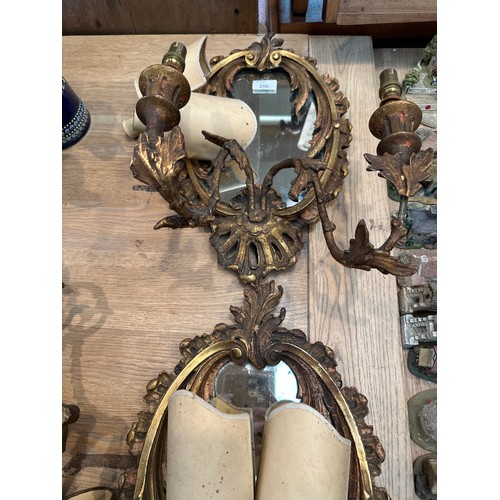 256 - A pair of oval sconces, with mirrored back and ornate floral carved gesso surround, 39cm High overal... 