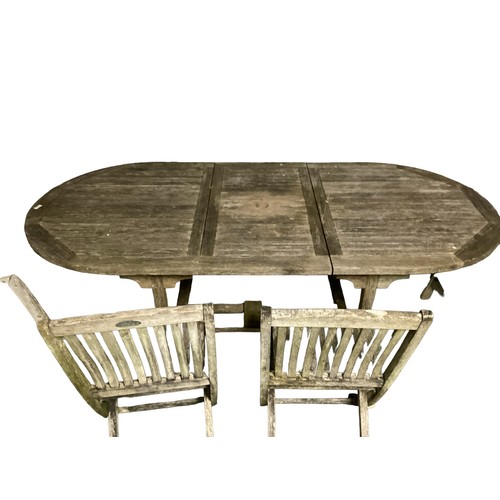 691 - A weathered teak garden table rectangular with oval ends, and an extension , 210 x 100cm wide x 75cm... 