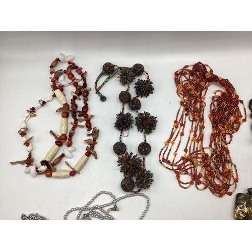 65 - A collection of costume and bead jewellery. A pair of amber drop ear rings. A jet style bead necklac... 