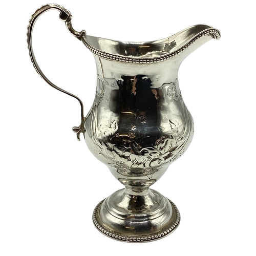 79 - A sterling silver cream jug with repoussé decoration on a beaded circular foot 103 g