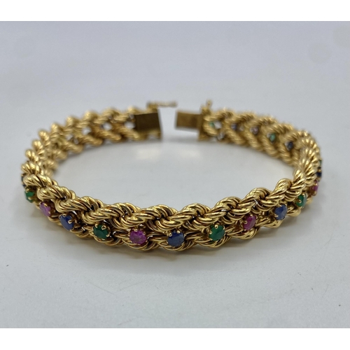 135 - An 18ct gold gem set bracelet. Alternating single cut emeralds , sapphires and Rubies. to a woven ro... 