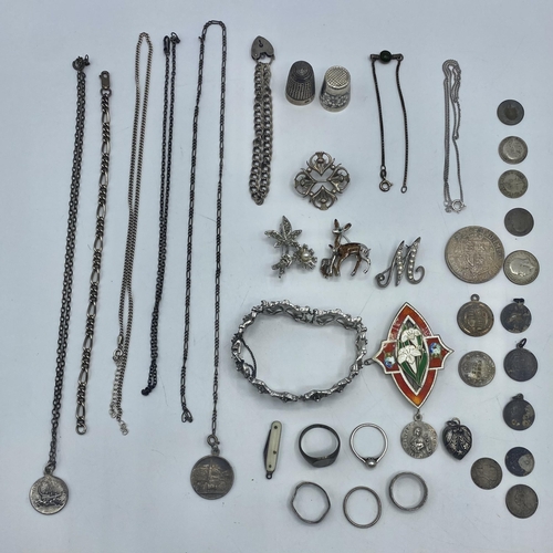 14 - A collection of sterling silver and white metal items to include an enamel brooch, thimbles pendants... 