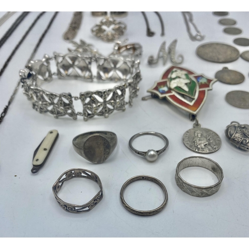 14 - A collection of sterling silver and white metal items to include an enamel brooch, thimbles pendants... 