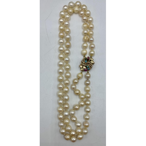 160 - A double strand pearl necklace with 14ct gold clasp set with rubies and turquoise. 42cm