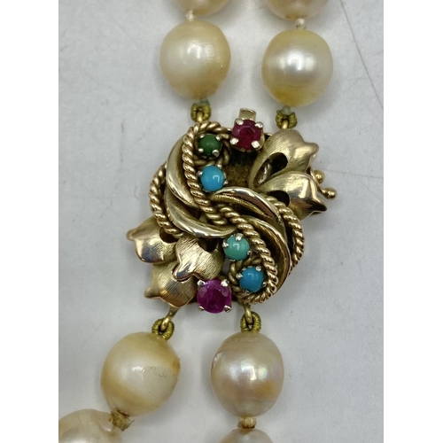 160 - A double strand pearl necklace with 14ct gold clasp set with rubies and turquoise. 42cm