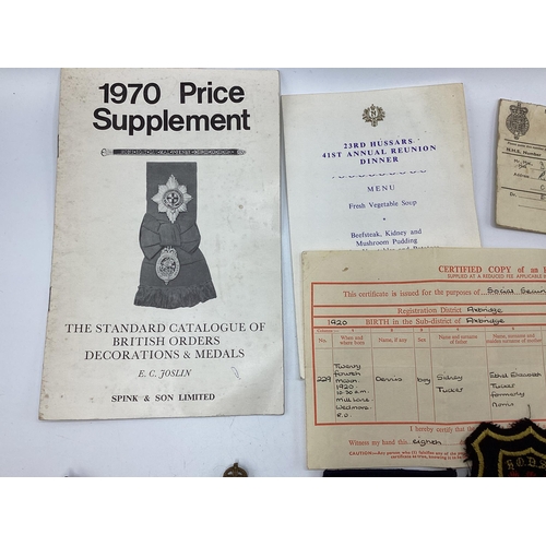 209 - A collection of Militaria to include cap badges , cloth insignia etc,