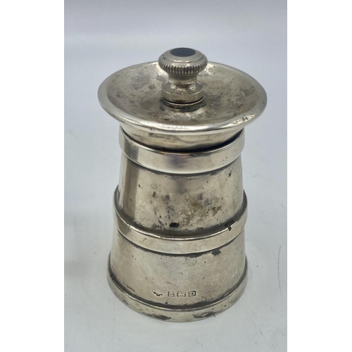 25 - A sterling silver mustard pot with blue glass liner London 1930 together with a sterling silver pepp... 