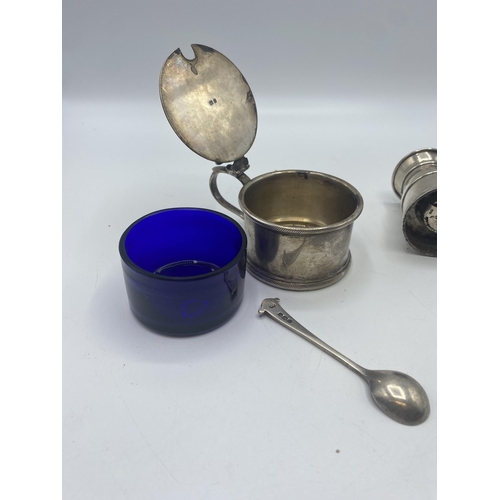 25 - A sterling silver mustard pot with blue glass liner London 1930 together with a sterling silver pepp... 