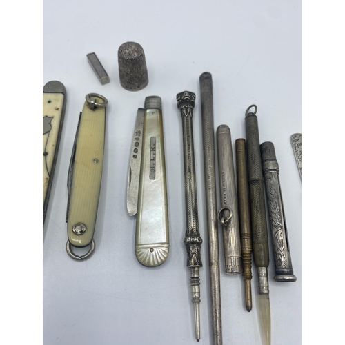 28 - A collection of sterling silver and white metal items to include a silver pencil holder, silver blad... 