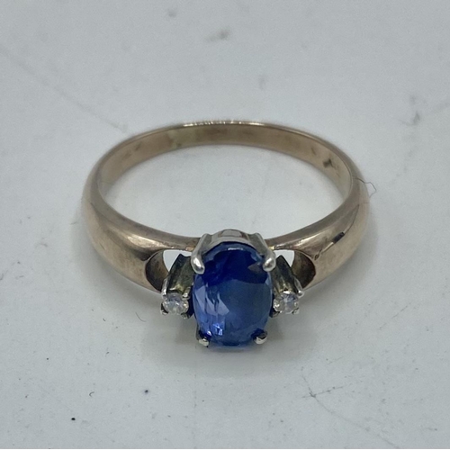 38 - An unmarked yellow metal sapphire and diamond ring. Central oval free cut sapphire with single cut d... 