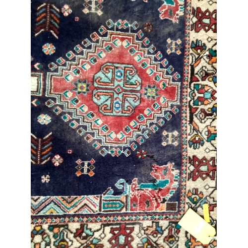 506 - Small blue rug with beige borders and three centred medallion 109 cm x 156 cm, some wear and damage ... 