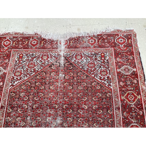 512 - Red rug in very worn condition and losses  140 cm x 200 cm sold as seen