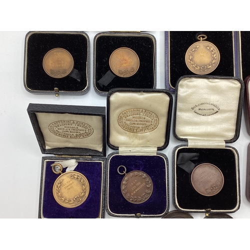 54 - A collection of bronze athletics medals 1920/30s to KW Hancock.