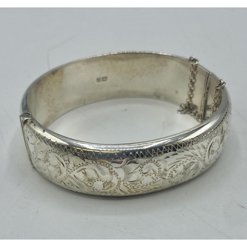 109 - A sterling silver bangle with etched decoration. 28g.