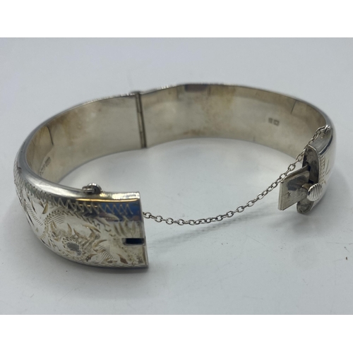 109 - A sterling silver bangle with etched decoration. 28g.