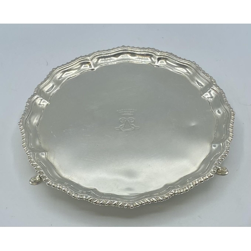 136 - A sterling silver circular card tray on three feet . 20.50cm. Carringtons & Co London, 1904. 345g.