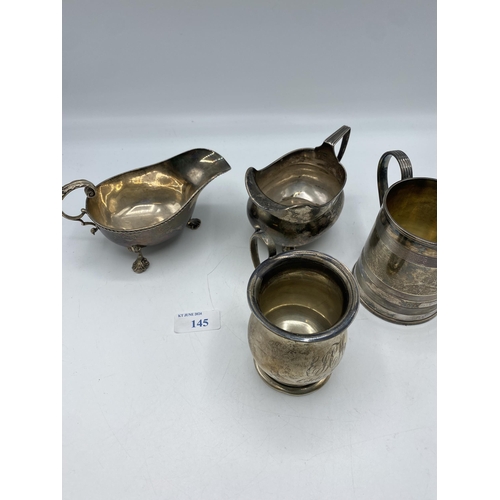 145 - A collection of sterling silver items to include a mug , cream jug, sauce boat etc. Various dates an... 