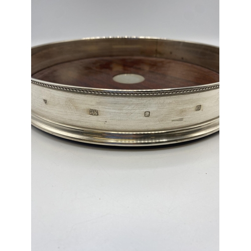 153 - A sterling silver circular tray with mahogany base by David Richards and Sons, London. 1998. 26cm(d)