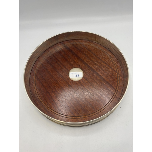 153 - A sterling silver circular tray with mahogany base by David Richards and Sons, London. 1998. 26cm(d)