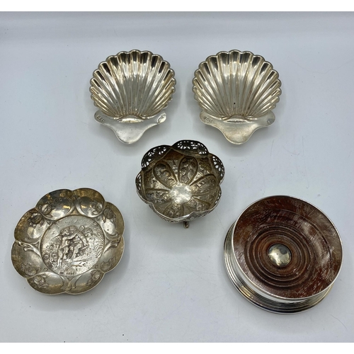 154 - A collection of sterling silver items to include a pair of scallop dishes, bottle coaster with turne... 