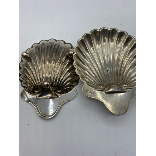154 - A collection of sterling silver items to include a pair of scallop dishes, bottle coaster with turne... 
