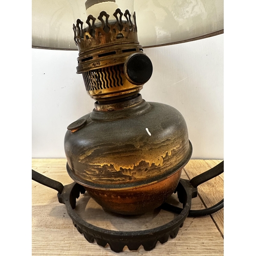 286 - A ceiling oil lamp with opaque white shaded and wrought iron mount. 70cm(h)