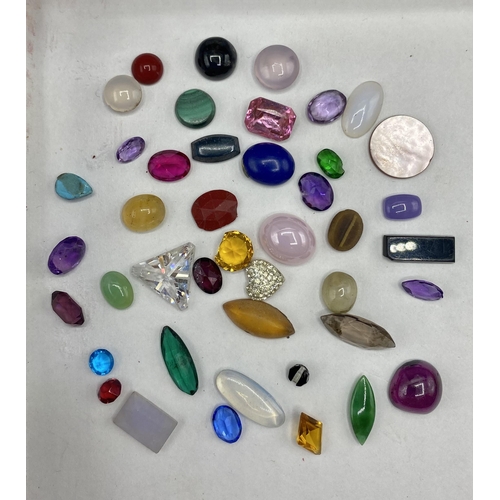 37 - A collection of gem stones and synthetic stones to include amethyst , moonstone, malachite, tigers e... 