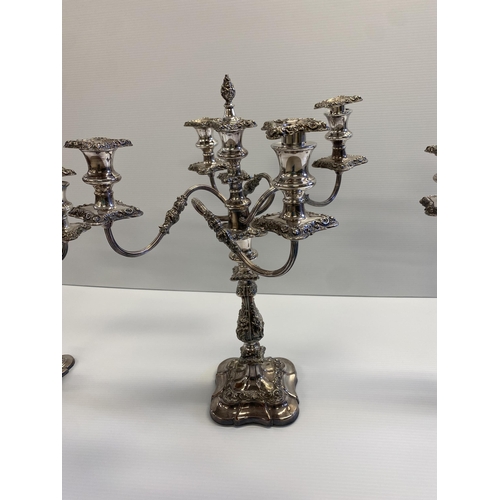 119 - Set of three silver plated table candelabra, central four branch with central holder with finial tog... 