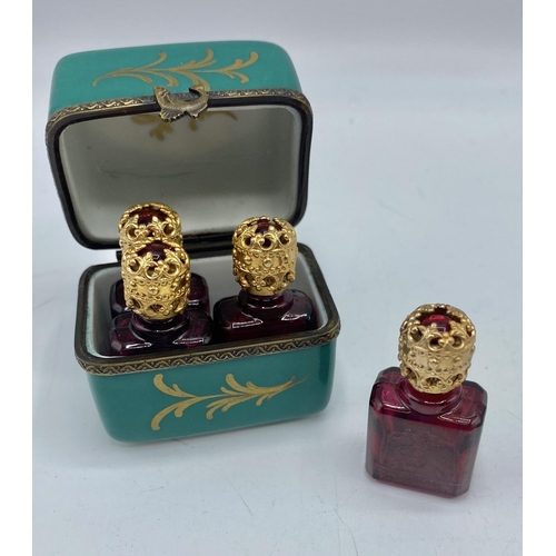 192 - A Limoges France hand painted perfume box containing four perfume bottles with gilt metal stoppers. ... 