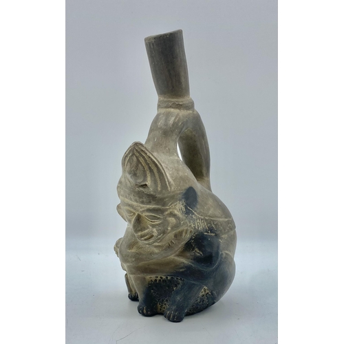 379 - A Moche stirrup spout figure vessel, Peru Terracotta of seated man with monkey. Circa 200BC. 21cm(h)