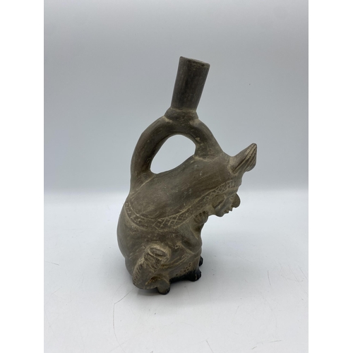 379 - A Moche stirrup spout figure vessel, Peru Terracotta of seated man with monkey. Circa 200BC. 21cm(h)