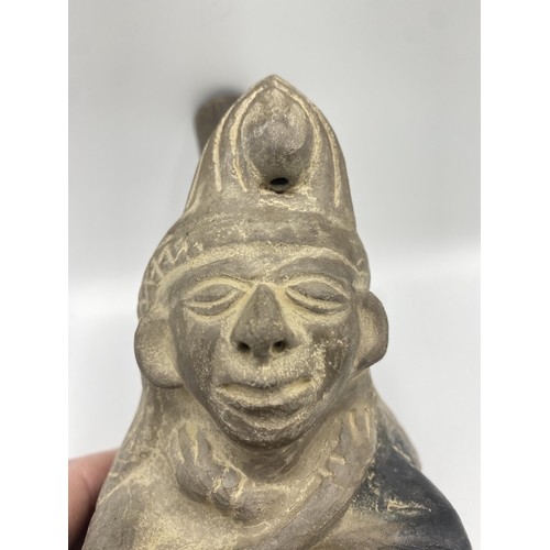 379 - A Moche stirrup spout figure vessel, Peru Terracotta of seated man with monkey. Circa 200BC. 21cm(h)