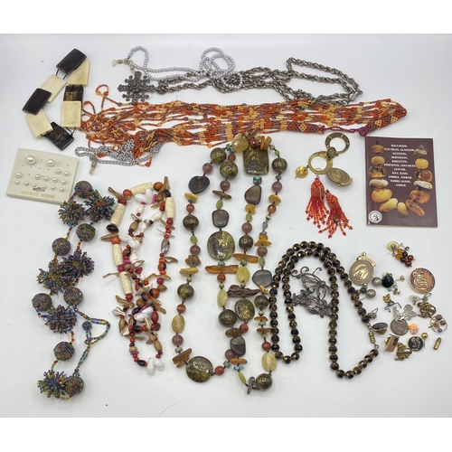 65 - A collection of costume and bead jewellery. A pair of amber drop ear rings. A jet style bead necklac... 