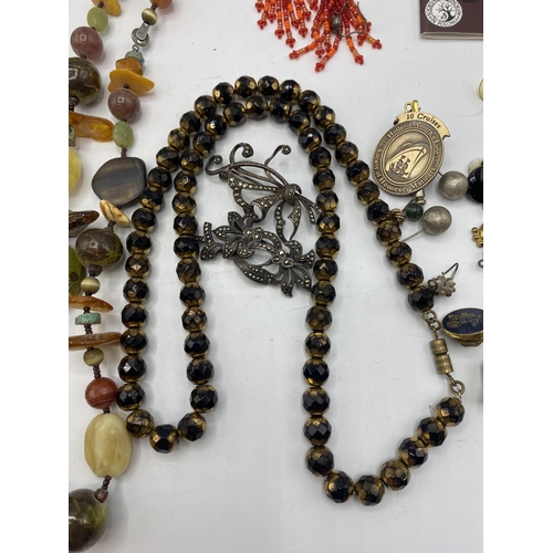 65 - A collection of costume and bead jewellery. A pair of amber drop ear rings. A jet style bead necklac... 