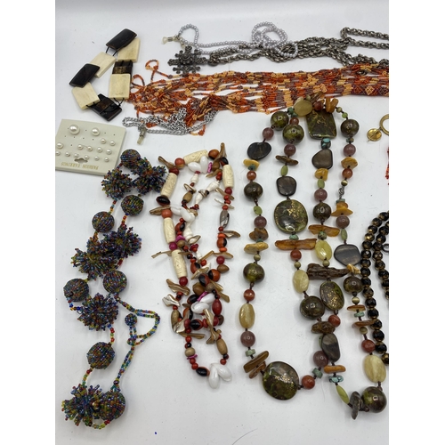 65 - A collection of costume and bead jewellery. A pair of amber drop ear rings. A jet style bead necklac... 