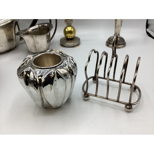 112 - A collection of sterling silver and white metal items to include three piece tea set a boxed pair of... 