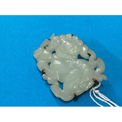 175 - An Oriental jade plaque brooch of a stylised temple lion. with white metal mount. 45mmx 35mm.