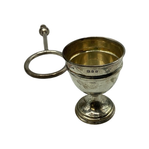 71 - A sterling silver egg cup holder with four egg cups and two spoons(two missing) on a sterling silver... 