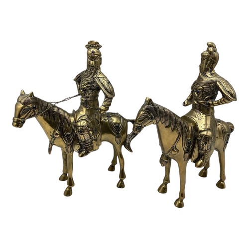 456 - A pair of Oriental brass figures of stylised knights on horseback each set with red and green glass ... 