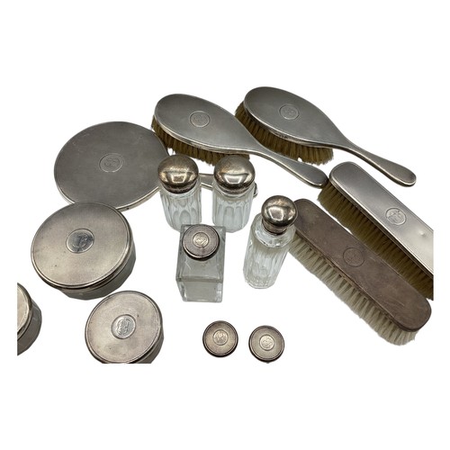 72 - A collection of sterling silver dressing table items to include a hand mirror and silver topped glas... 