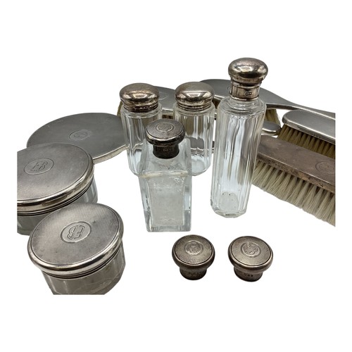 72 - A collection of sterling silver dressing table items to include a hand mirror and silver topped glas... 