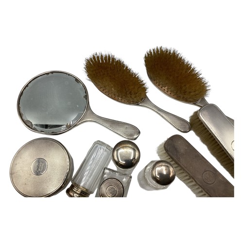 72 - A collection of sterling silver dressing table items to include a hand mirror and silver topped glas... 