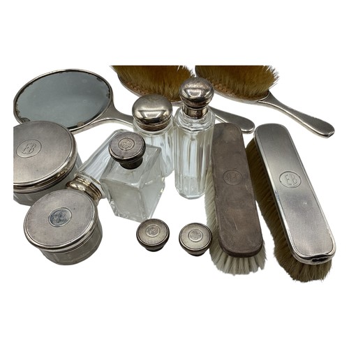 72 - A collection of sterling silver dressing table items to include a hand mirror and silver topped glas... 