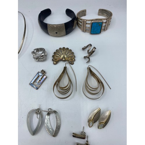 61 - A collection of sterling silver and white metal jewellery to include torques, earrings, pendants, ne... 