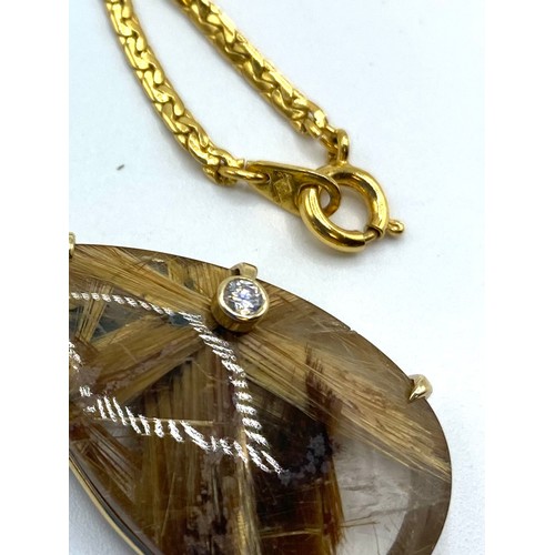 47 - a rutilated quartz pendant in unmarked yellow metal mount with single bezel set brilliant cut diamon... 